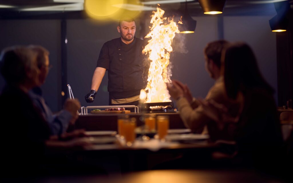 Teppanyaki chef training on a grill with lots of fire